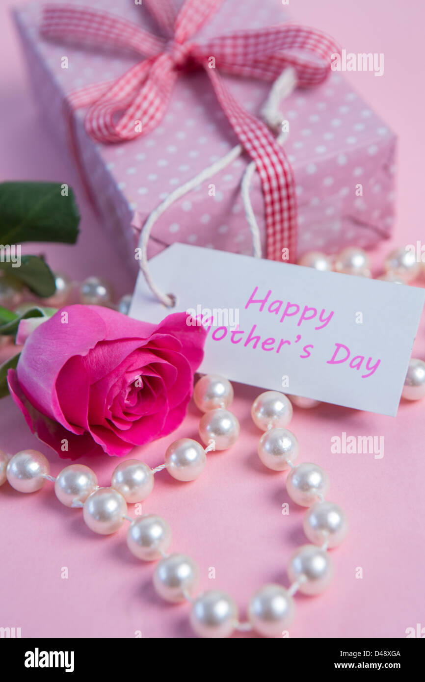 Pink rose with gift and string of pearls for mothers day Stock Photo