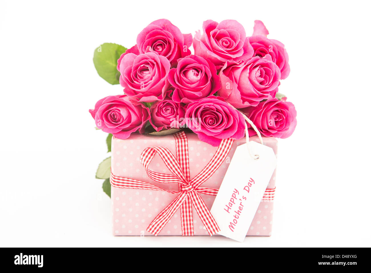 Bouquet of pink roses next to a pink gift with a happy mothers day card ...