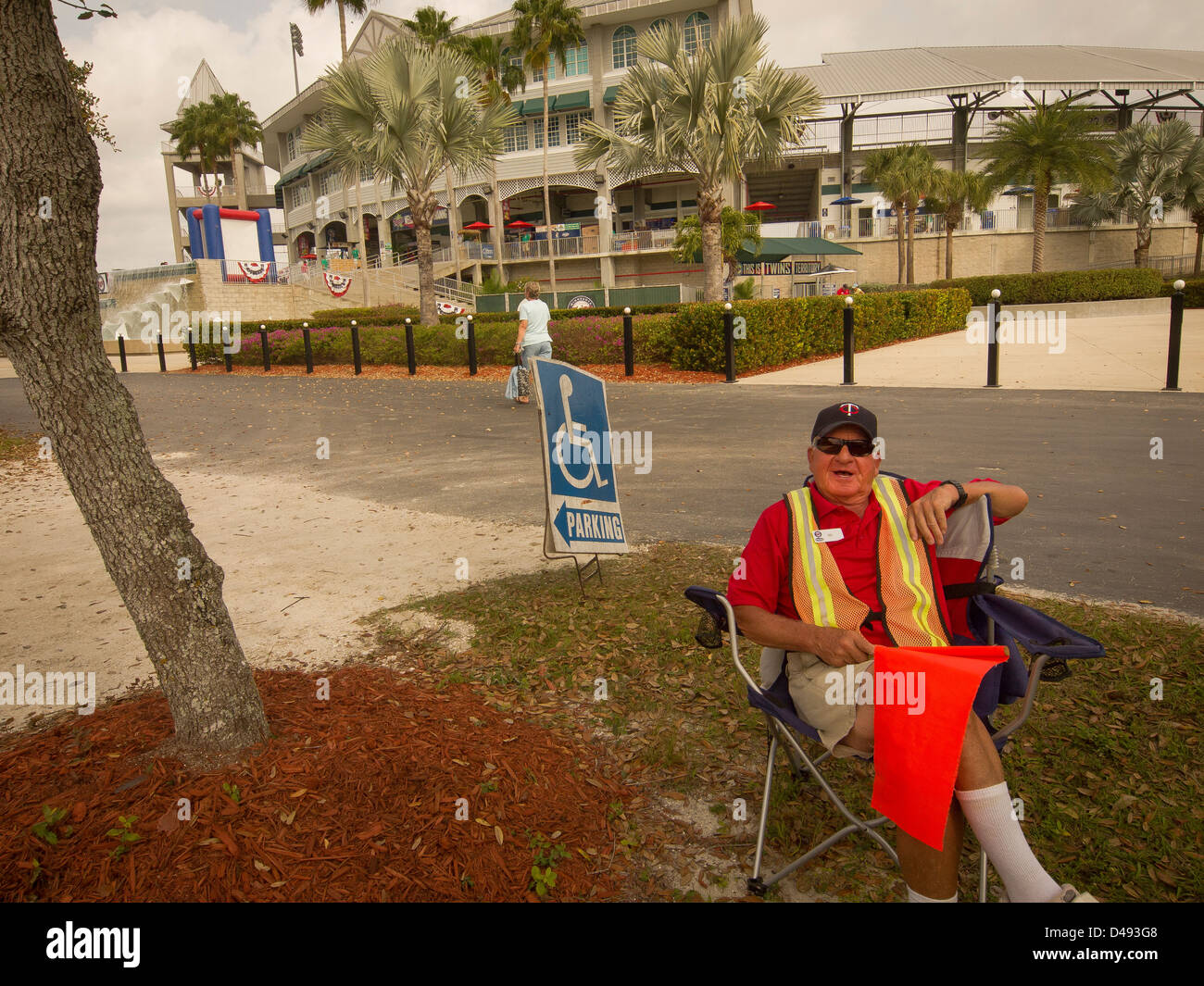 Retiree takes it easy as a parking lot attendant  helping baseball fans watch major league baseball teams in Florida. Stock Photo
