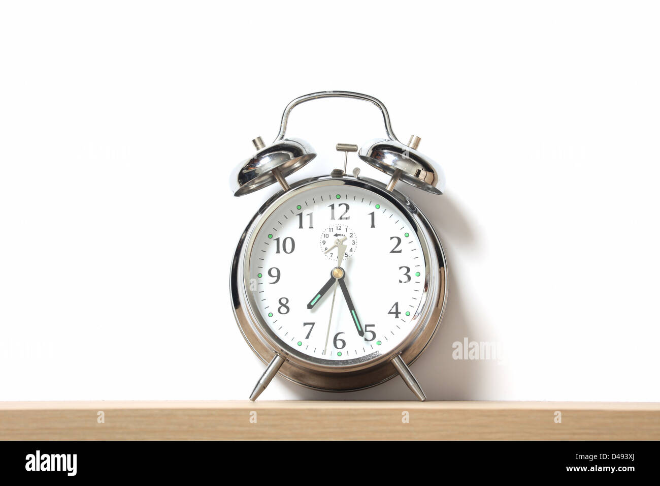 Chrome alarm clock with bells on, set just after 7-25. Stock Photo