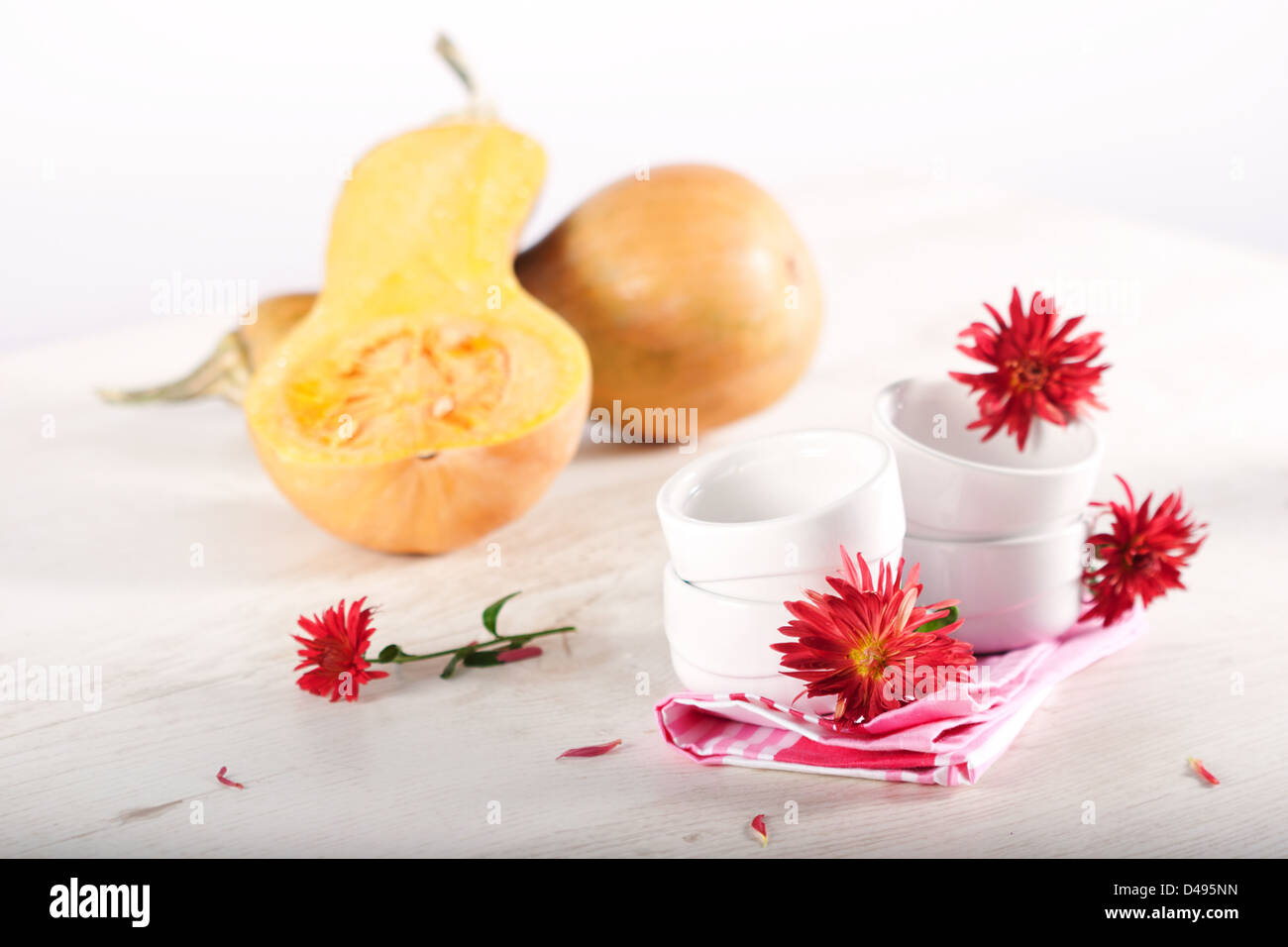 Pumpkins, cooking utensil and autumn flowers. Stock Photo