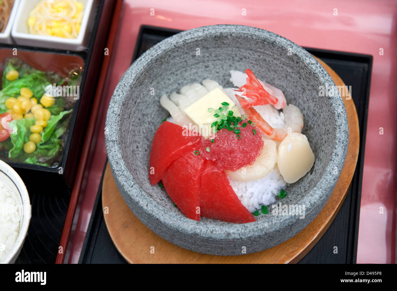 Plastic food display of maguro sashimi (raw tuna), ika (squid), ebi (shrimp) and hotategai (scallops) on rice looks appetizing Stock Photo
