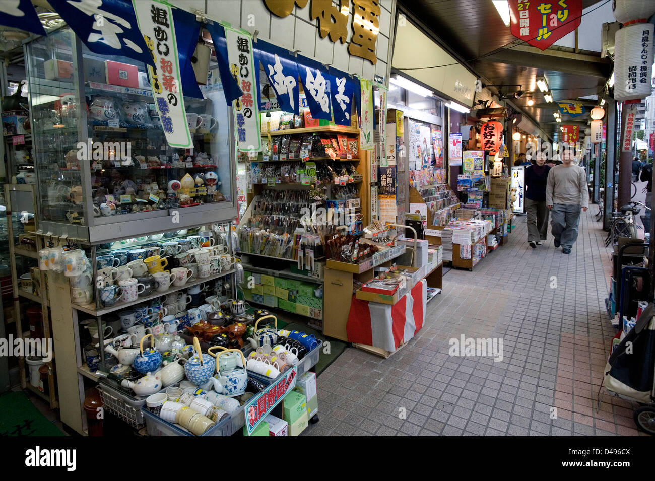 Goods spilling out onto a public sidewalk from shops in the Tsukishima district of Tokyo, Japan Stock Photo
