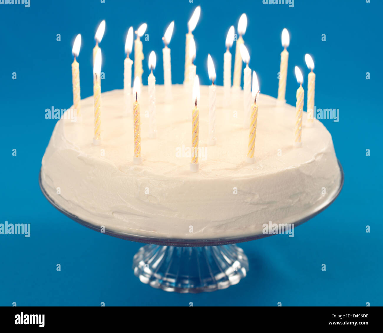 Birthday cake with burning candles on blue background Stock Photo - Alamy