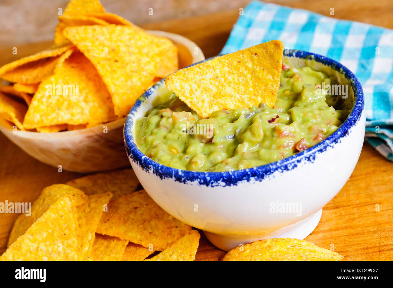 Tortilla chips with guacamole dip Stock Photo