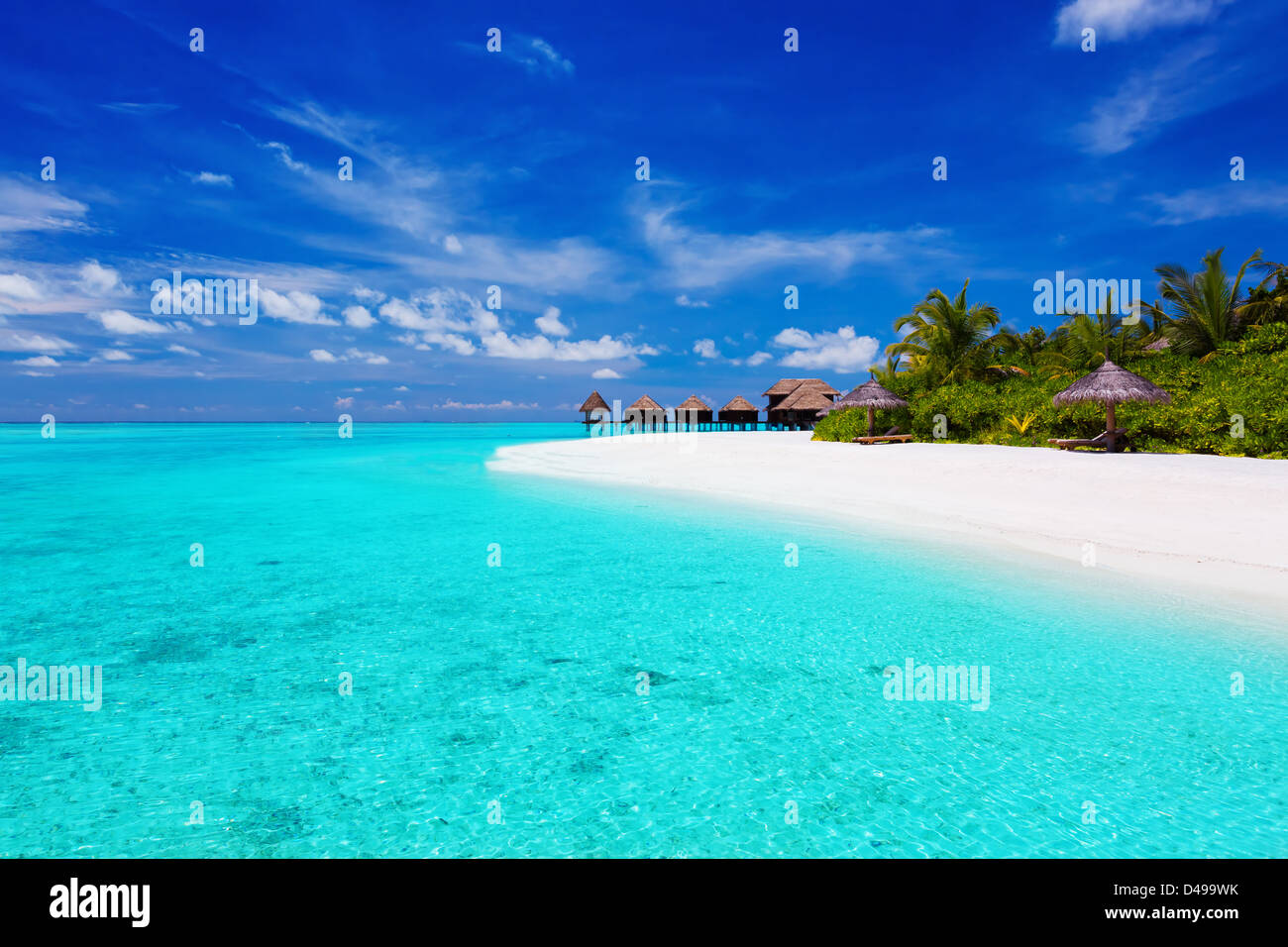 Tropical island with palm trees and villas over turquoise lagoon Stock Photo
