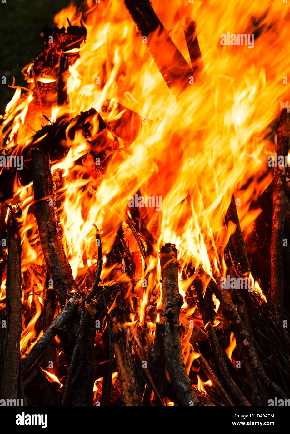 Burning sticks piled up to build a traditional camp fire with large
