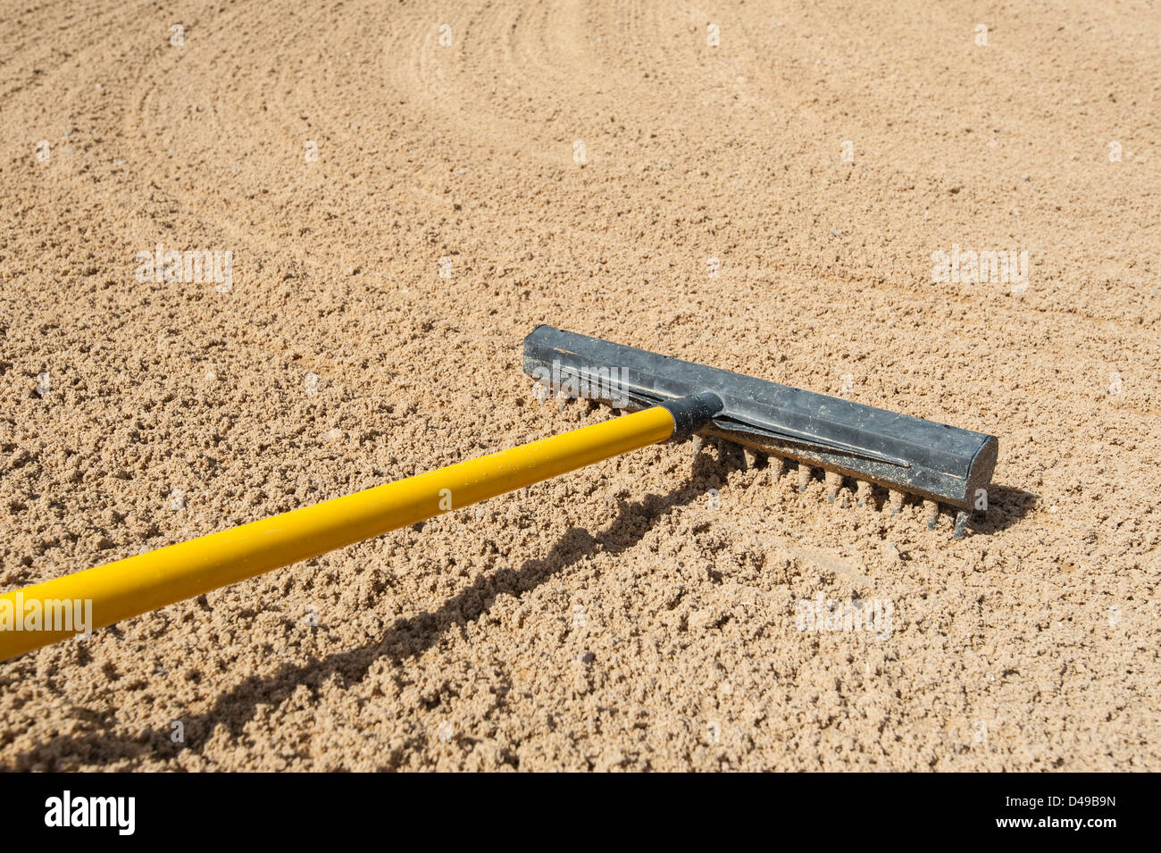 Rake in a bunker on golf course Stock Photo