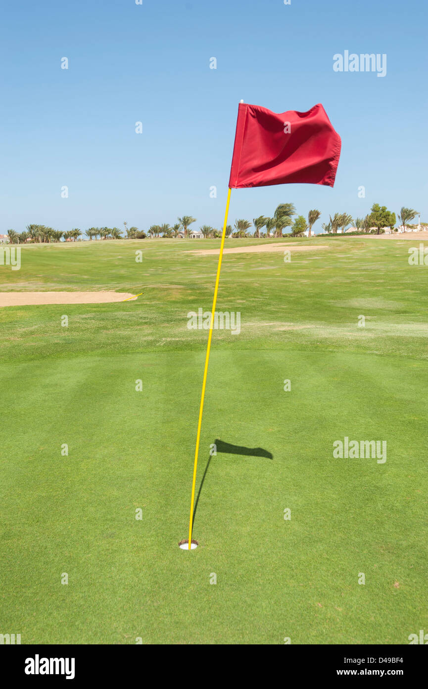 Flag in the hole on a golf course green Stock Photo