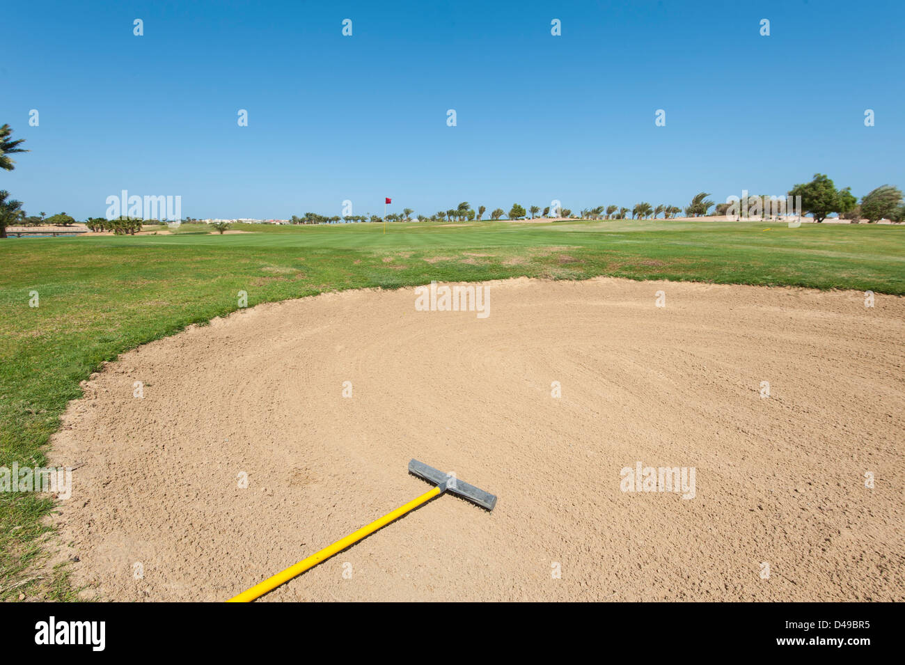 Bunker sand trap on a golf course with green in the distance Stock