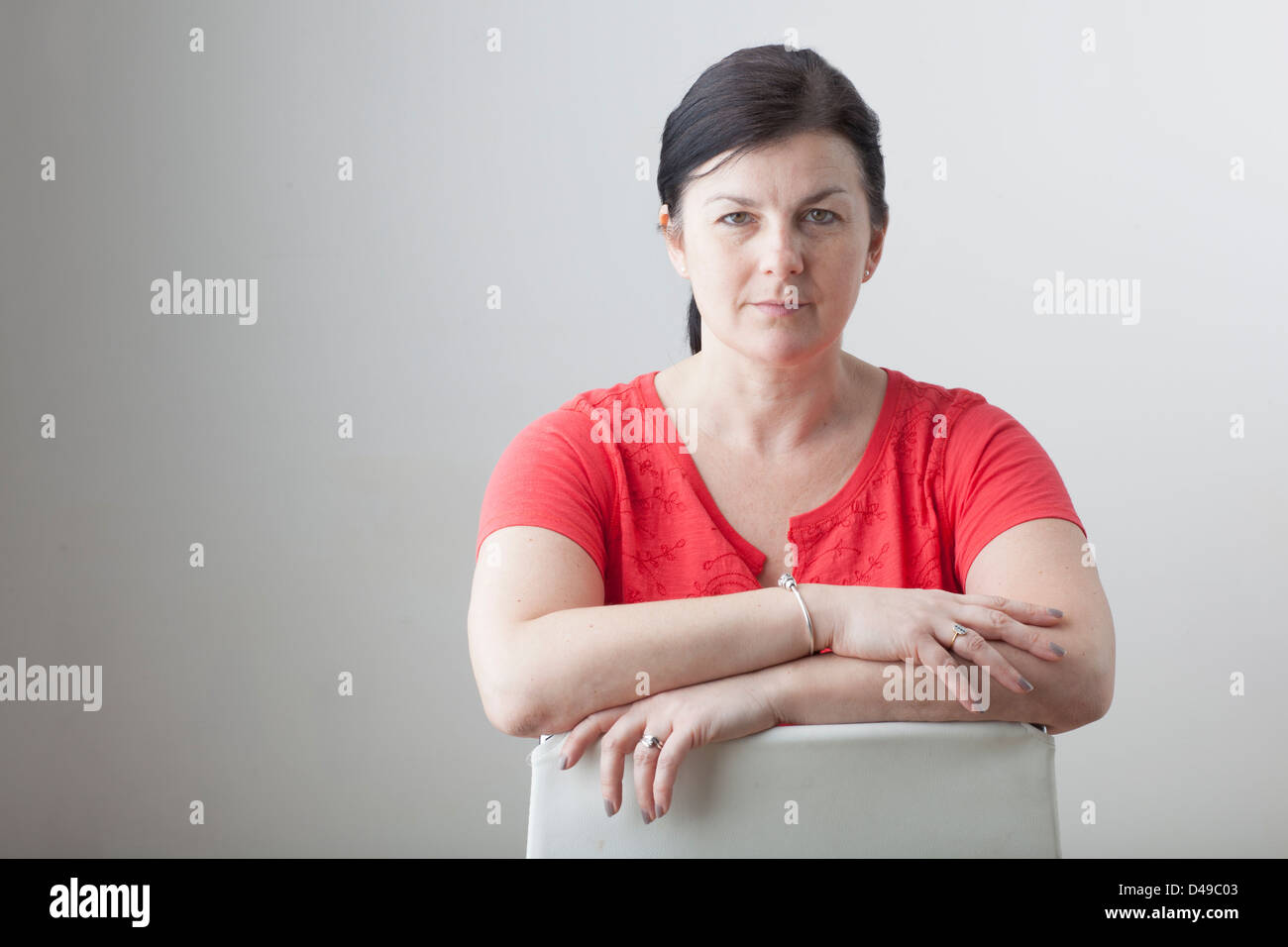 Woman sitting with arms crossed hi-res stock photography and images - Alamy