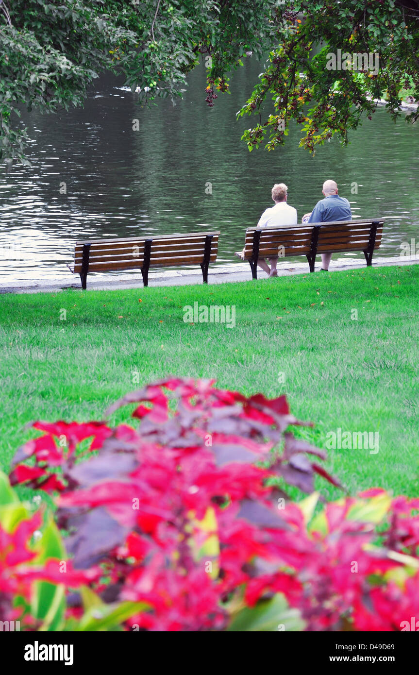 Senior couple sitting on a park bench Stock Photo - Alamy