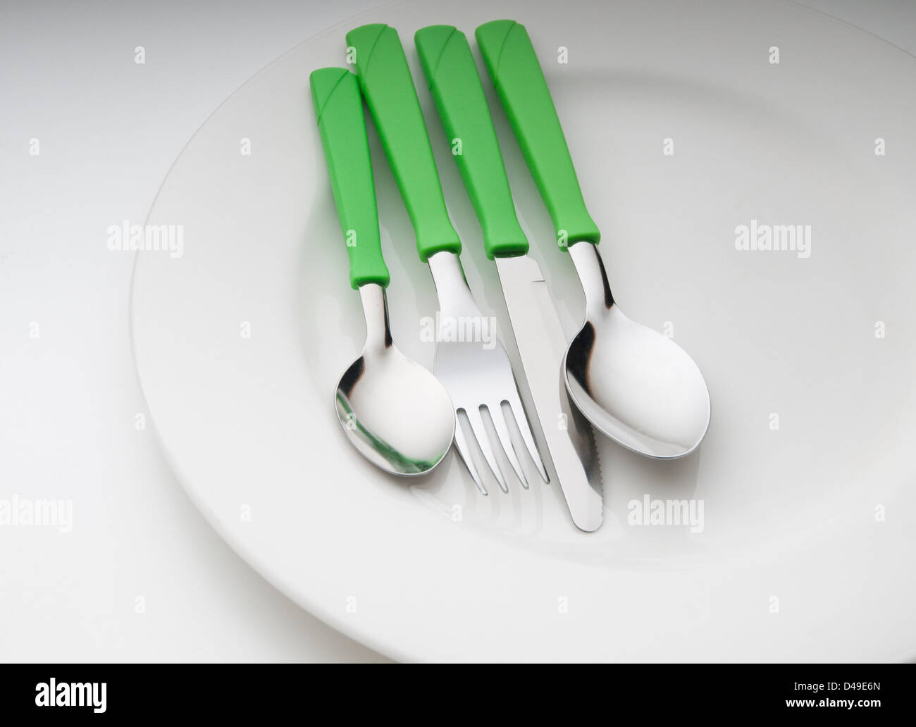 metal cutlery and plate in color on table Stock Photo