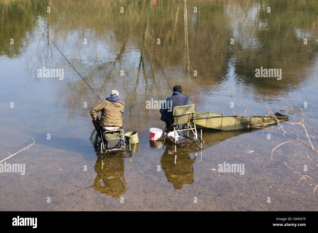 Hereford, two men fishing in the River Wye, sat on fishing chairs with lots  of accessories and gear Stock Photo - Alamy