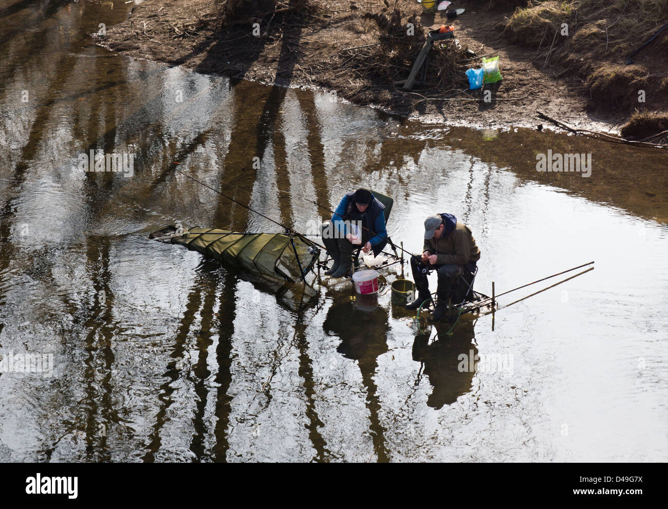 Hereford, two men fishing in the River Wye, sat on fishing chairs with lots  of accessories and gear Stock Photo - Alamy