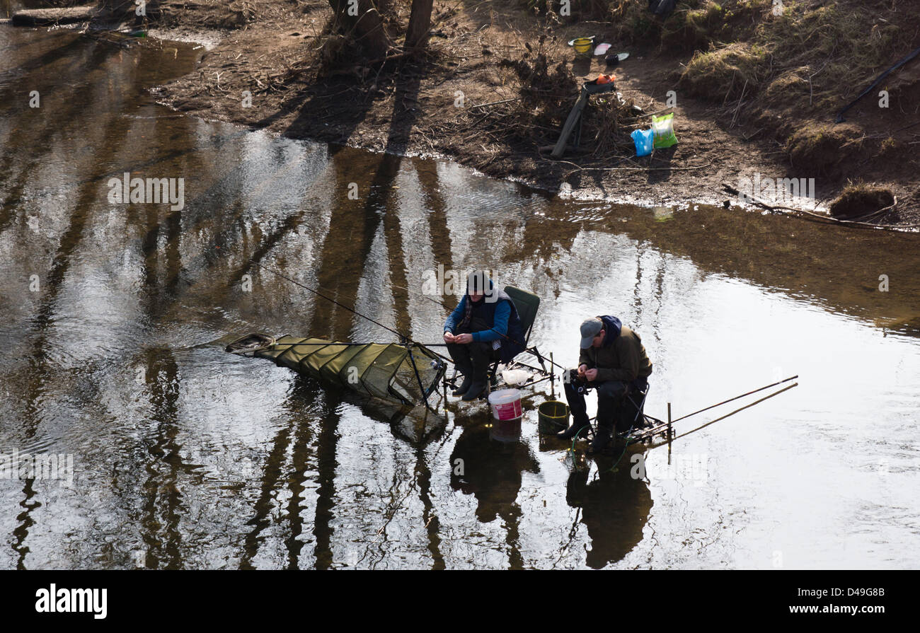Hereford, two men fishing in the River Wye, sat on fishing chairs with lots of accessories and