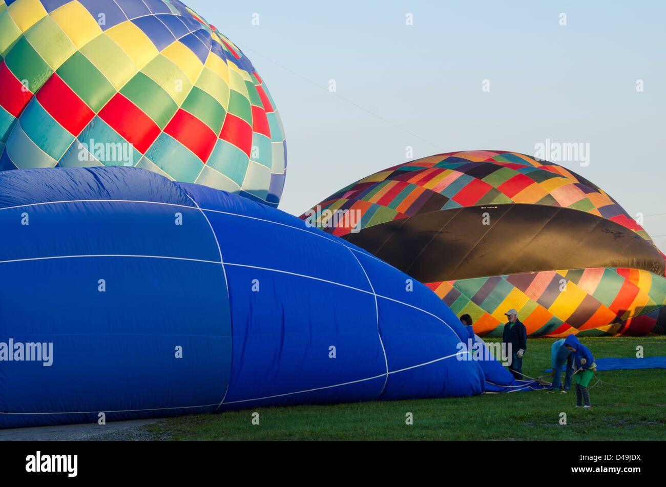 A hot air balloon crew works to inflate the envelope of their balloon