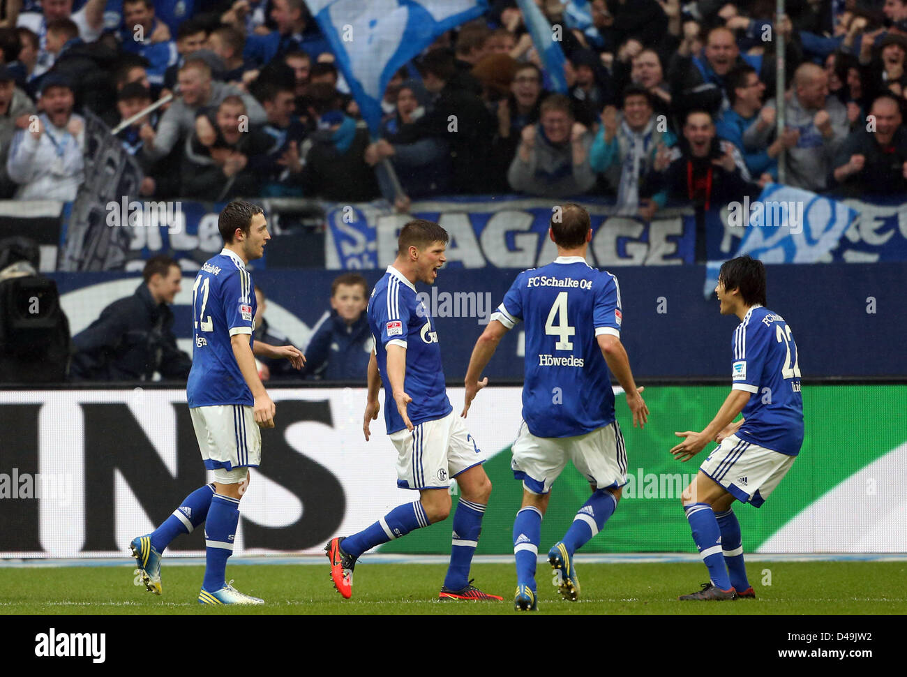 Gelsenkirchen, Germany. 9th March 2013. Schalke's Klaas-Jan Huntelaar (2-L) celebrates his 2-0 goal with teammates Marco Hoeger (L-R), Benedikt Hoewedes and Atsuto Uchida during the Bundesliga soccer match between FC Schalke 04 and Borussia Dortmund at Veltins-Arena in Gelsenkirchen, Germany, 09 March 2013. Photo: FRISO GENTSCH  (ATTENTION: EMBARGO CONDITIONS! The DFL permits the further  utilisation of up to 15 pictures only (no sequntial pictures or video-similar series of pictures allowed) via the internet and online media during the match (including halftime), taken from inside the stadium Stock Photo