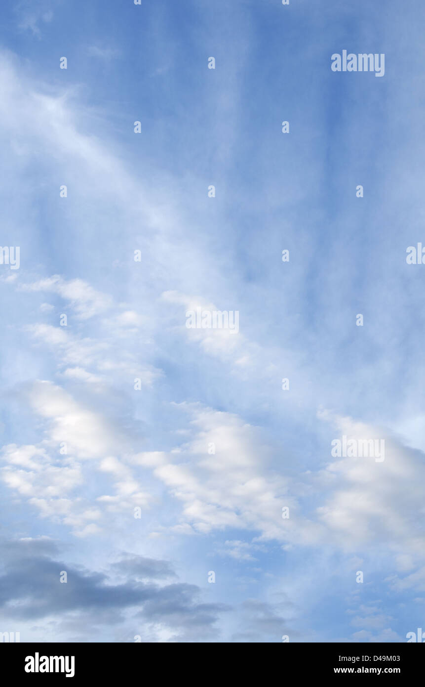 Lines of wispy cirrus and stratus clouds streak a blue sky Stock Photo