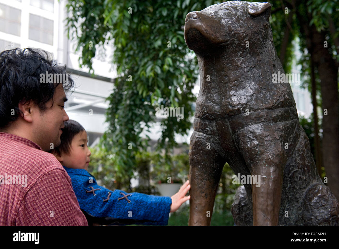 Father with child greeting the famous 'faithful dog' statue of Chuken Hachiko in Shibuya, Tokyo, Japan Stock Photo