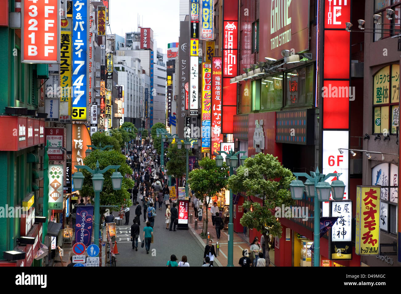 Neon advertising signs cover building facades in the retail and entertainment district of Minami Shinjuku in Tokyo. Stock Photo