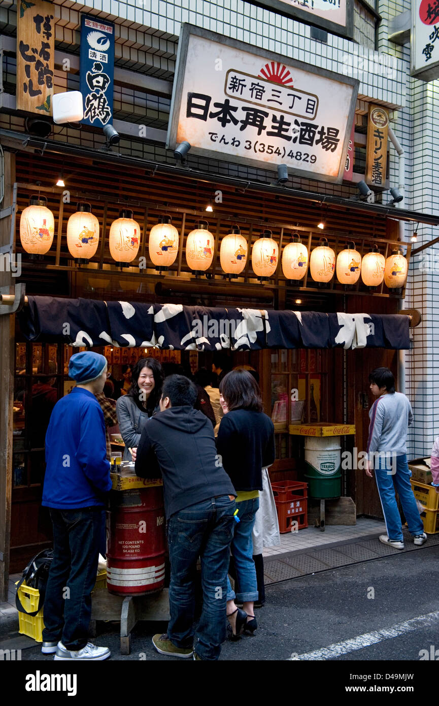 Patrons enjoying themselves over a few beers streetside at a pub in Shinjuku, Tokyo, Japan. Stock Photo