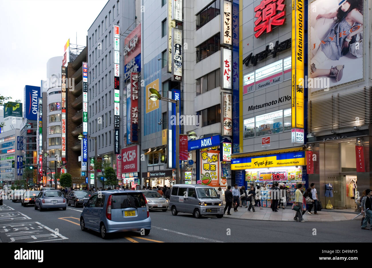 Busy street with neon sign advertising building facades in the entertainment and shopping district of East Shunjuku, Tokyo. Stock Photo