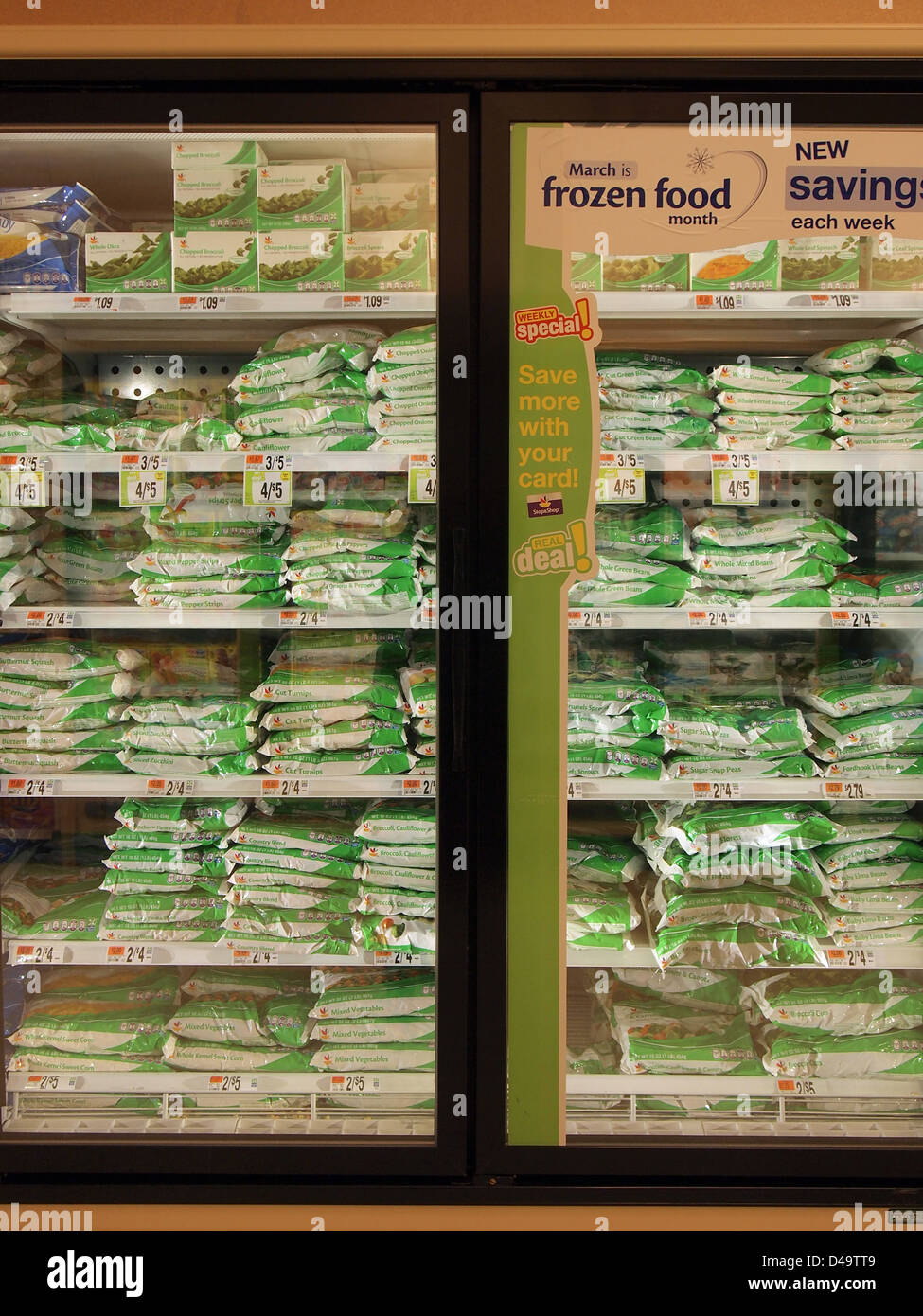 Bags of frozen vegetables on sale in a freezer case at a supermarket, New York, USA,  March 9, 2013, © Katharine Andriotis Stock Photo