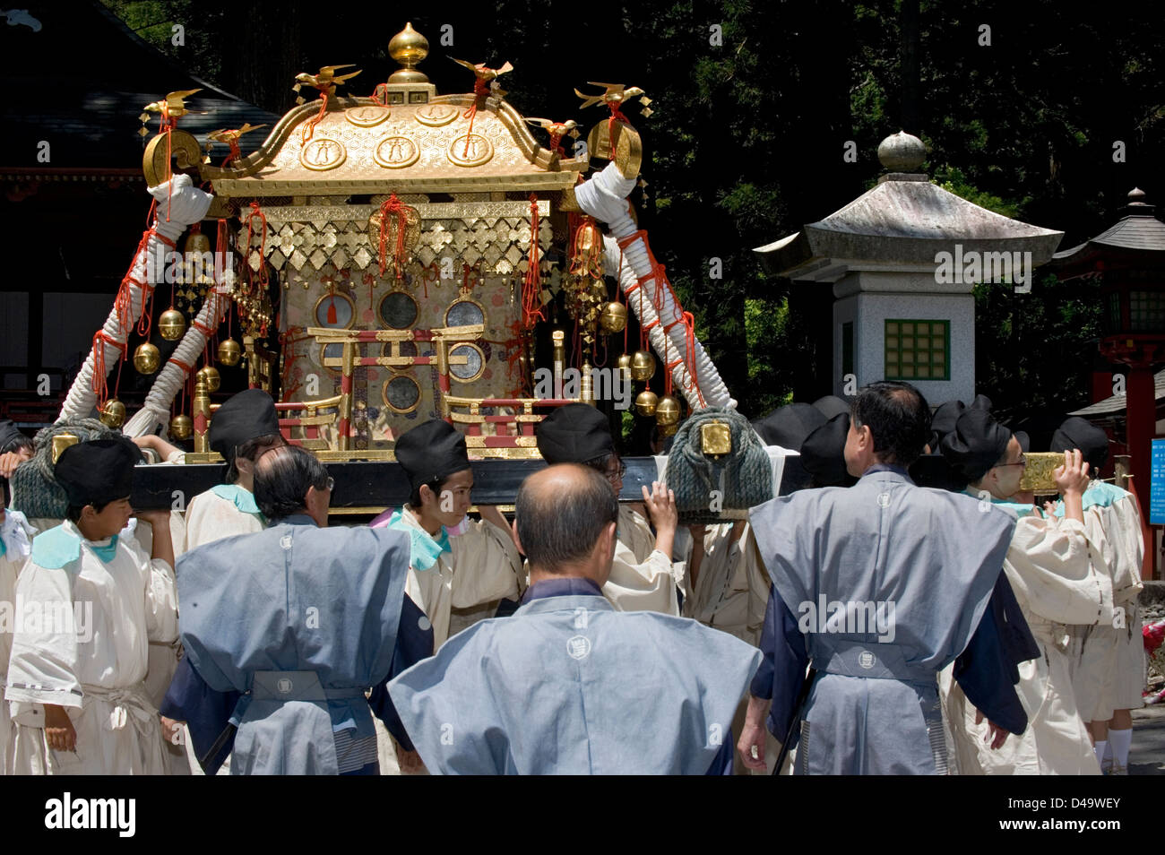 Participants at Futarasan Shrine for annual spring Shunki Reitaisai festival in Nikko, Tochigi, Japan carry gold mikoshi shrine Stock Photo