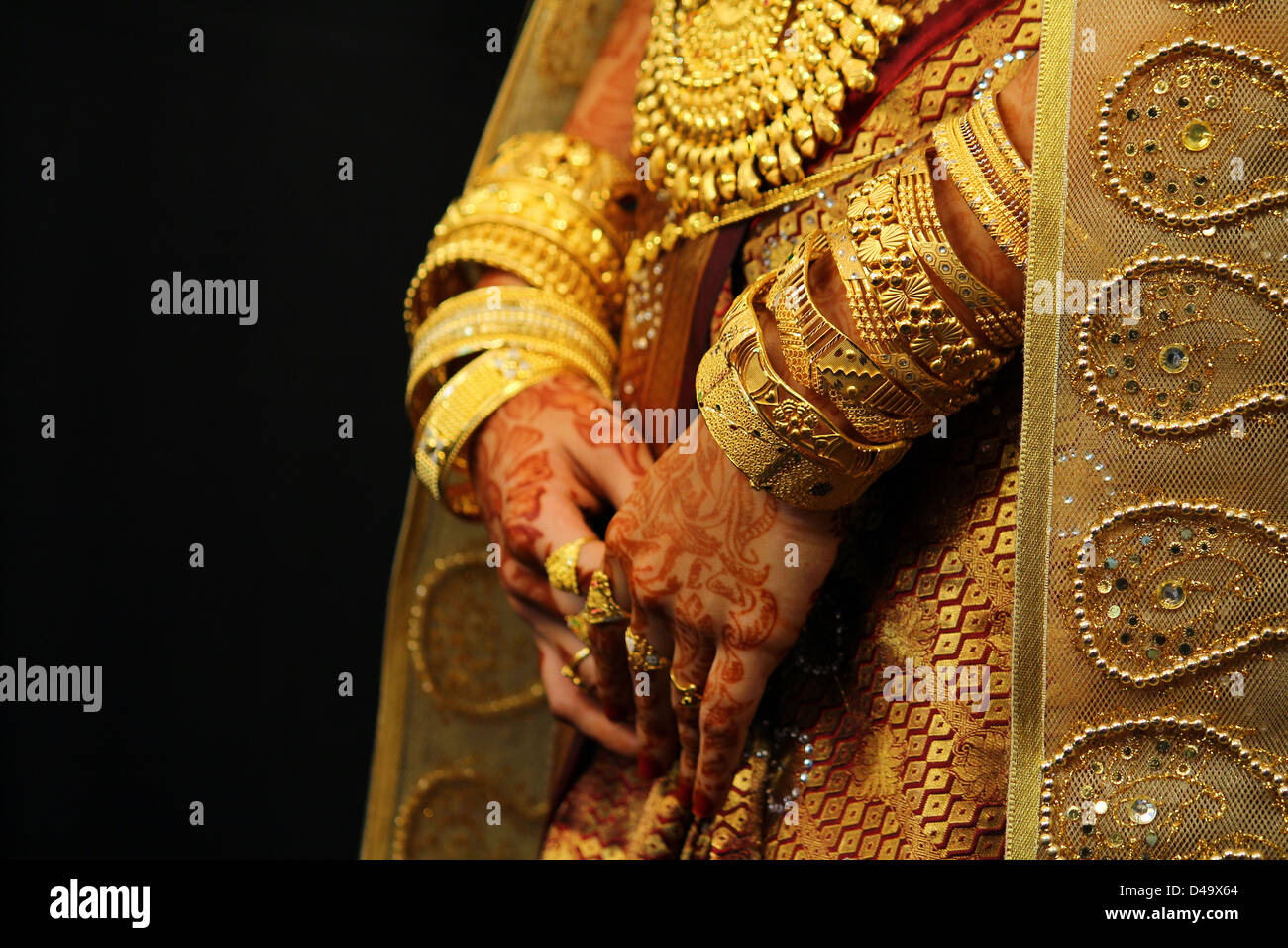 rich gold jewelery on the hands of a muslim bride in india Stock Photo