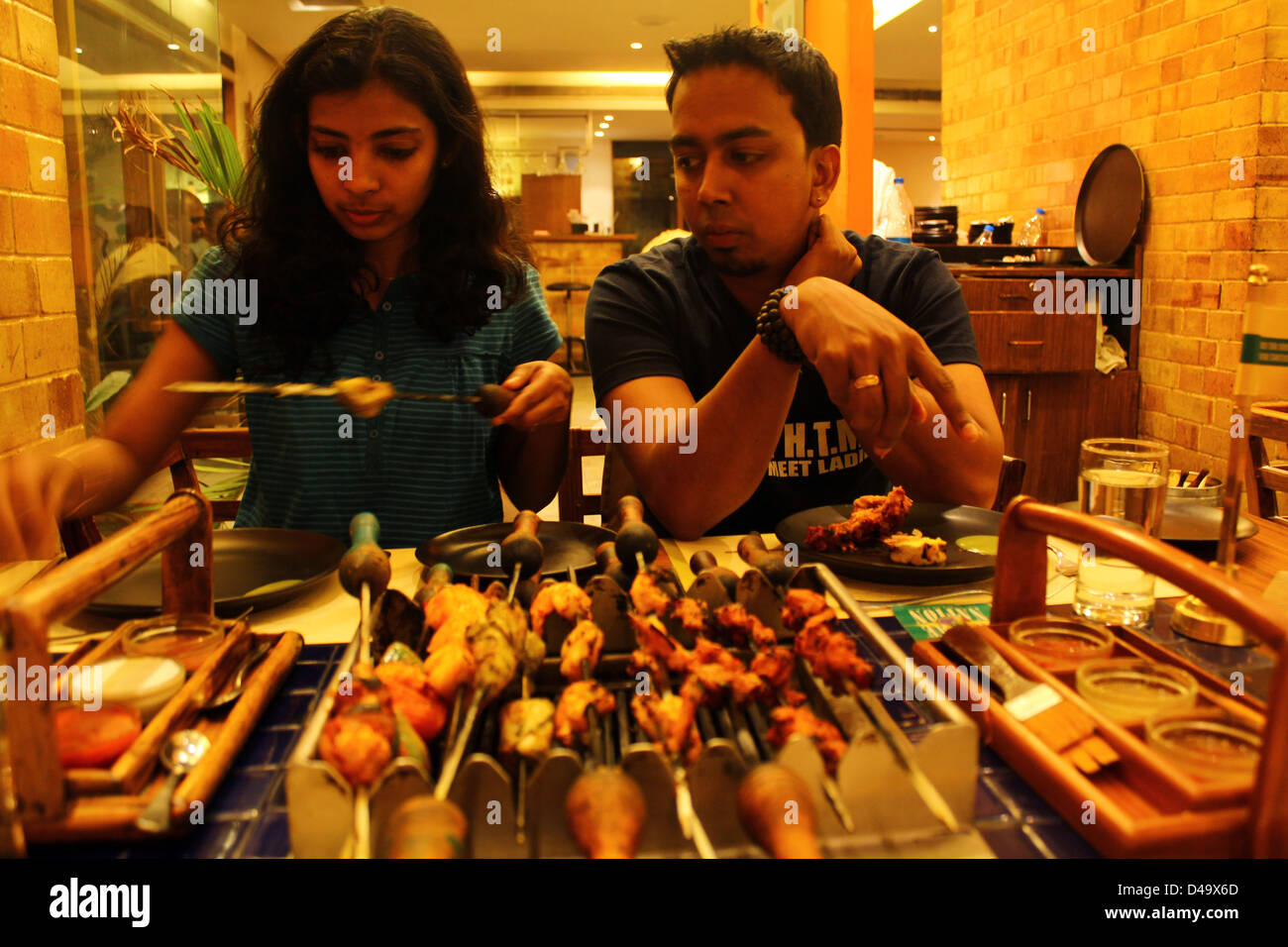 Young couple eating barbecue at a restaurant in Bangalore india Stock