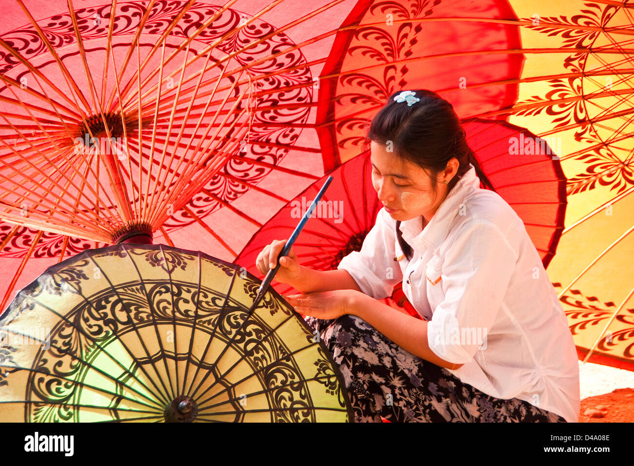 Young woman painting decorative designs at umbrella workshop in Old Bagan, Myanmar (Burma) Stock Photo