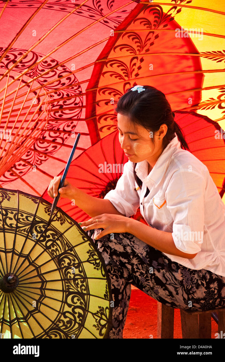 Young woman painting designs at umbrella workshop in Old Bagan, Myanmar (Burma) Stock Photo