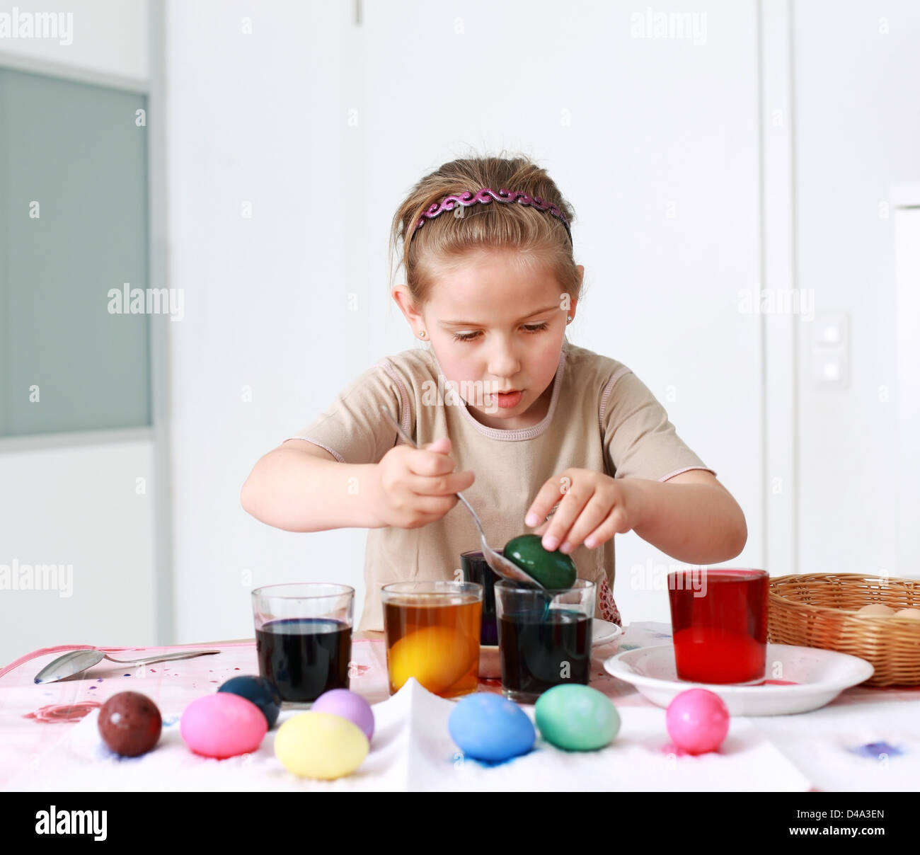 Portrait of schoolgirl painting Easter eggs Stock Photo