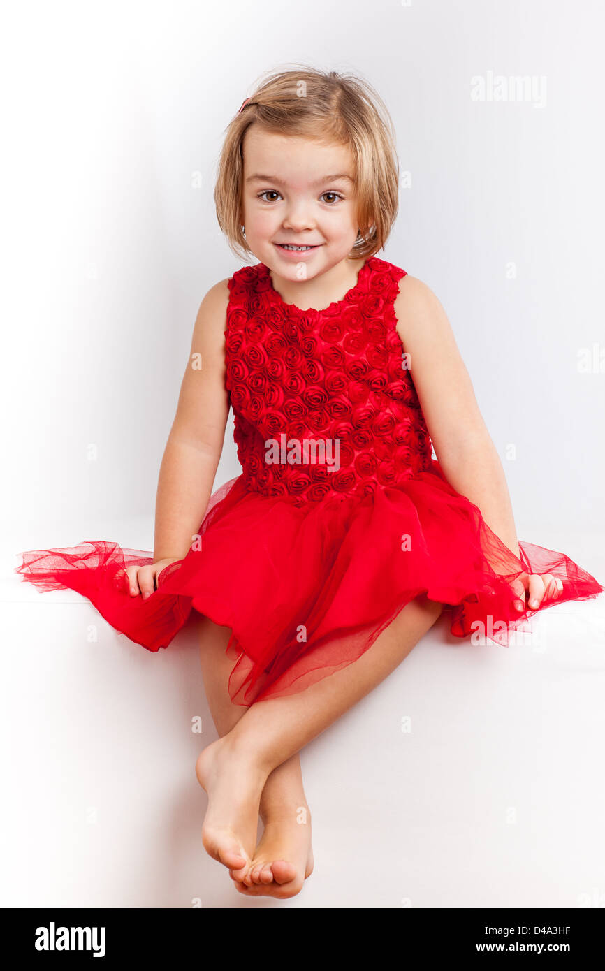 Beautiful little girl in red dresses Stock Photo - Alamy