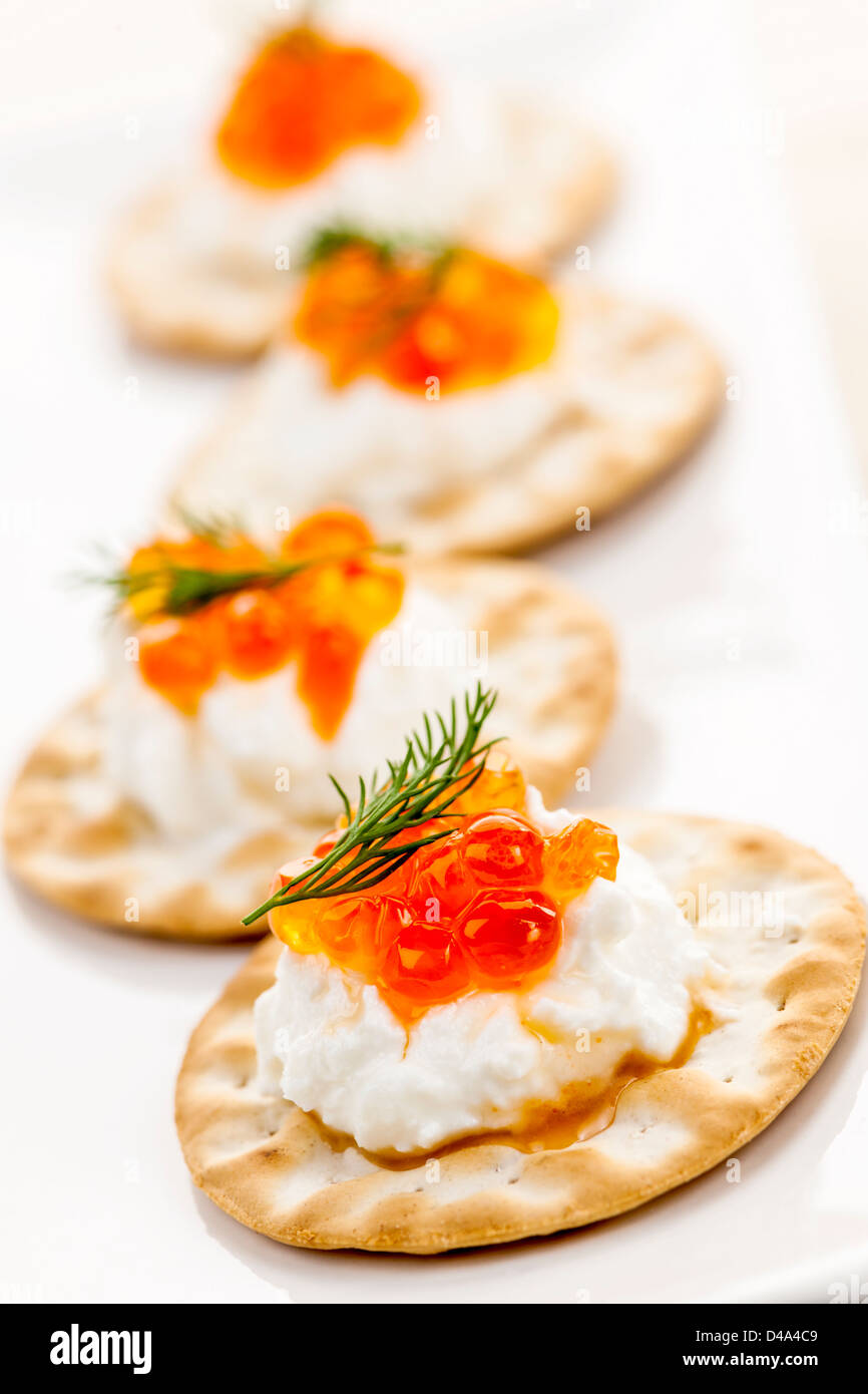 Closeup of caviar and cream cheese appetizer on crackers Stock Photo