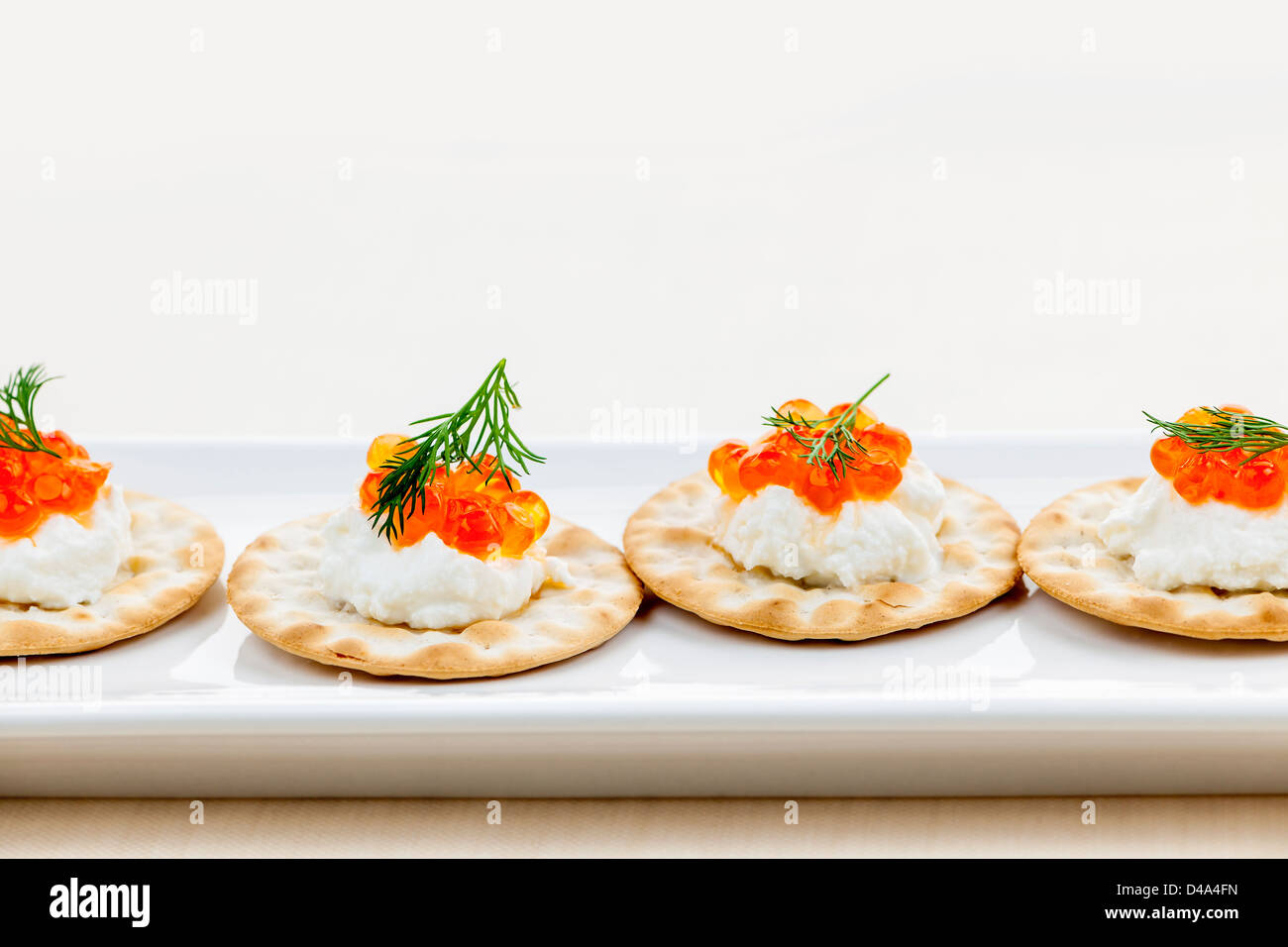 Caviar appetizer with goat cheese and crackers on white plate Stock