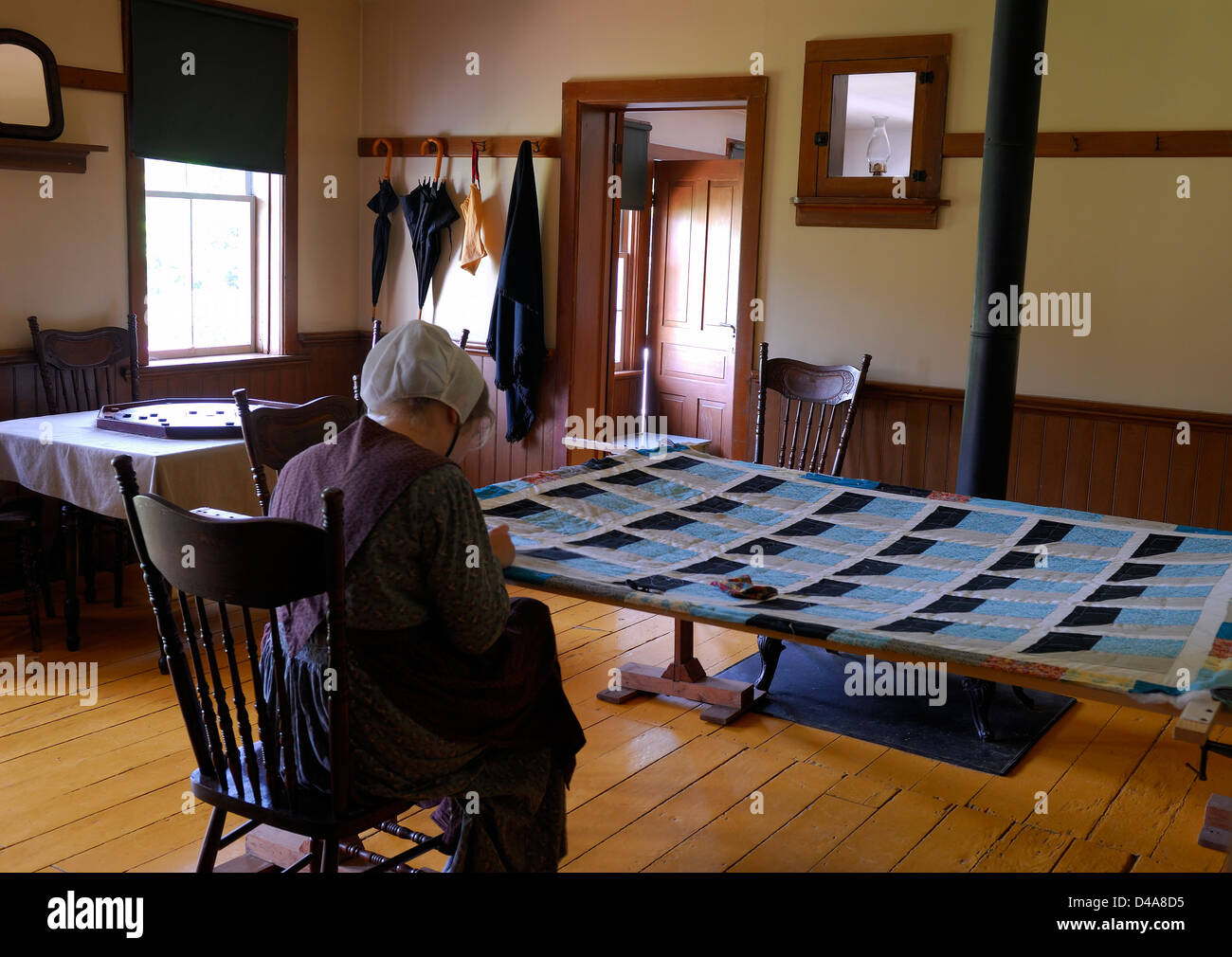 Mennonite woman sewing a patchwork quilt at Doon Heritage Crossroads Kitchener Waterloo Ontario Canada Stock Photo