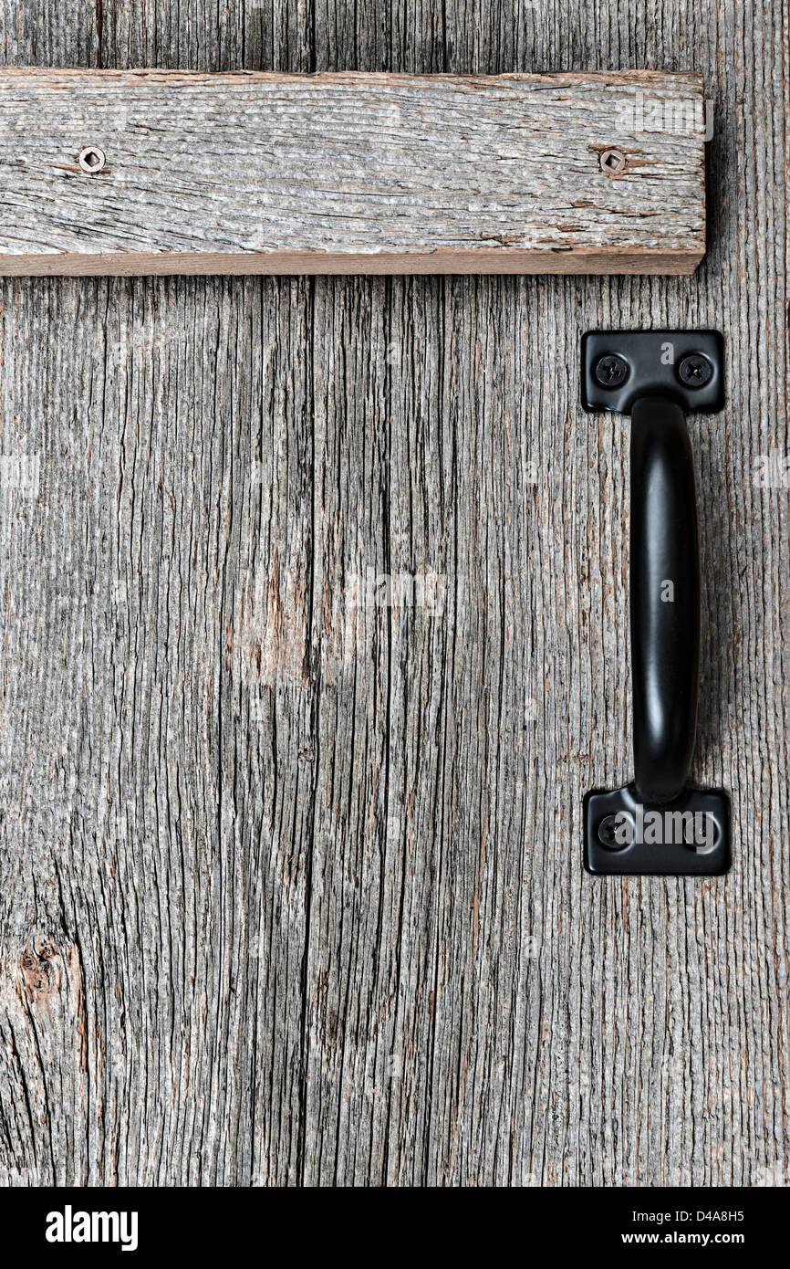 Distressed rustic barn wood door with handle as textured background Stock Photo