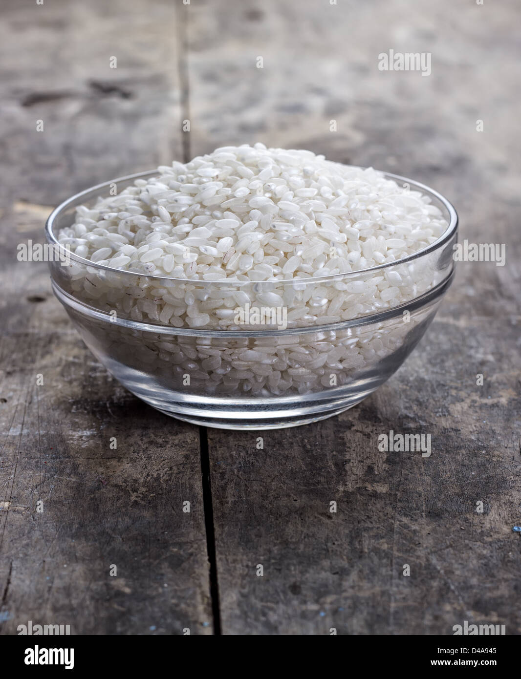 rice in a glass bowl on old wooden table Stock Photo