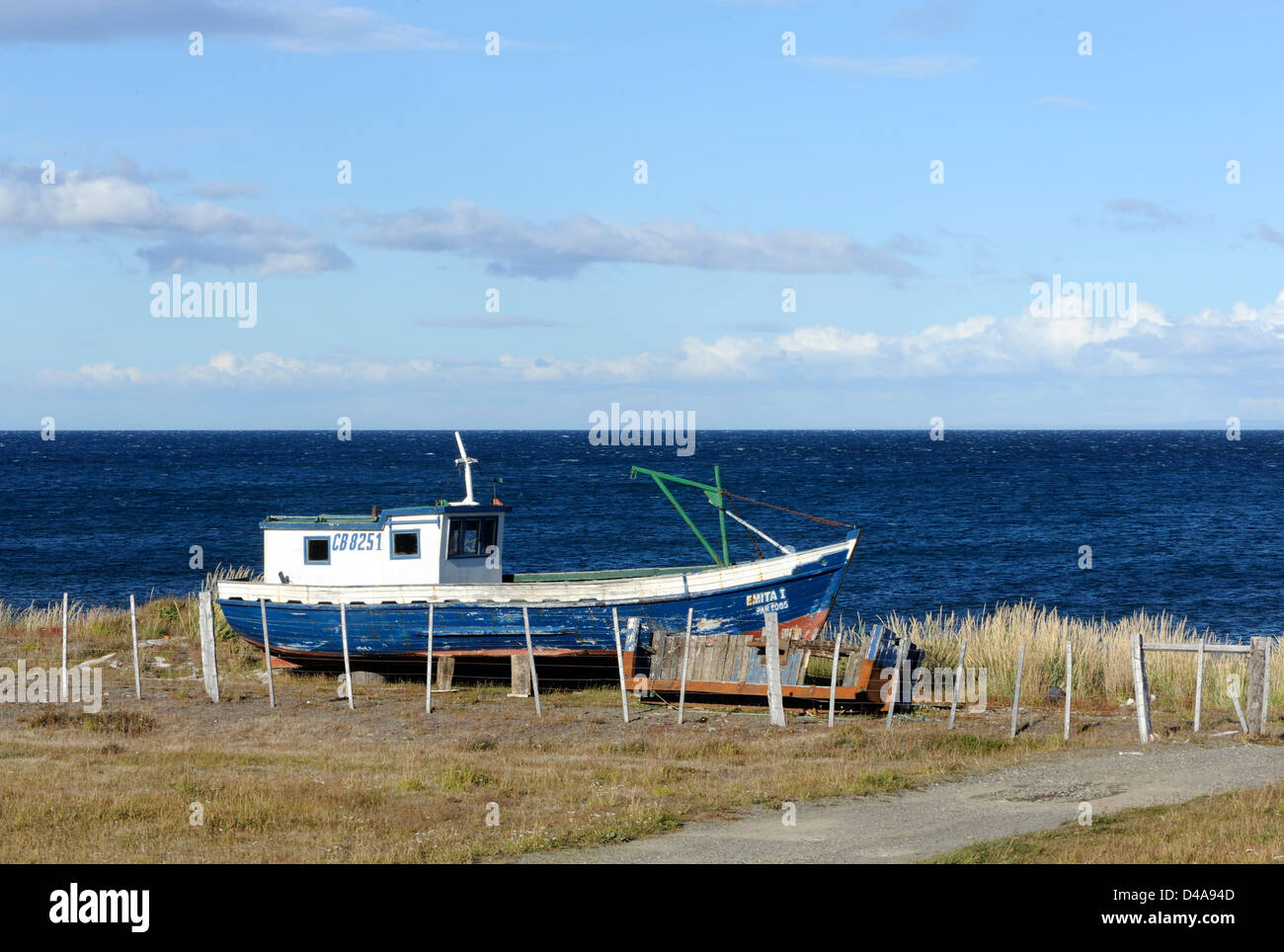 Old wooden fishing boat pulled up above the beach on the Strait of Magellan .  Punta Arenas, Chile. Stock Photo