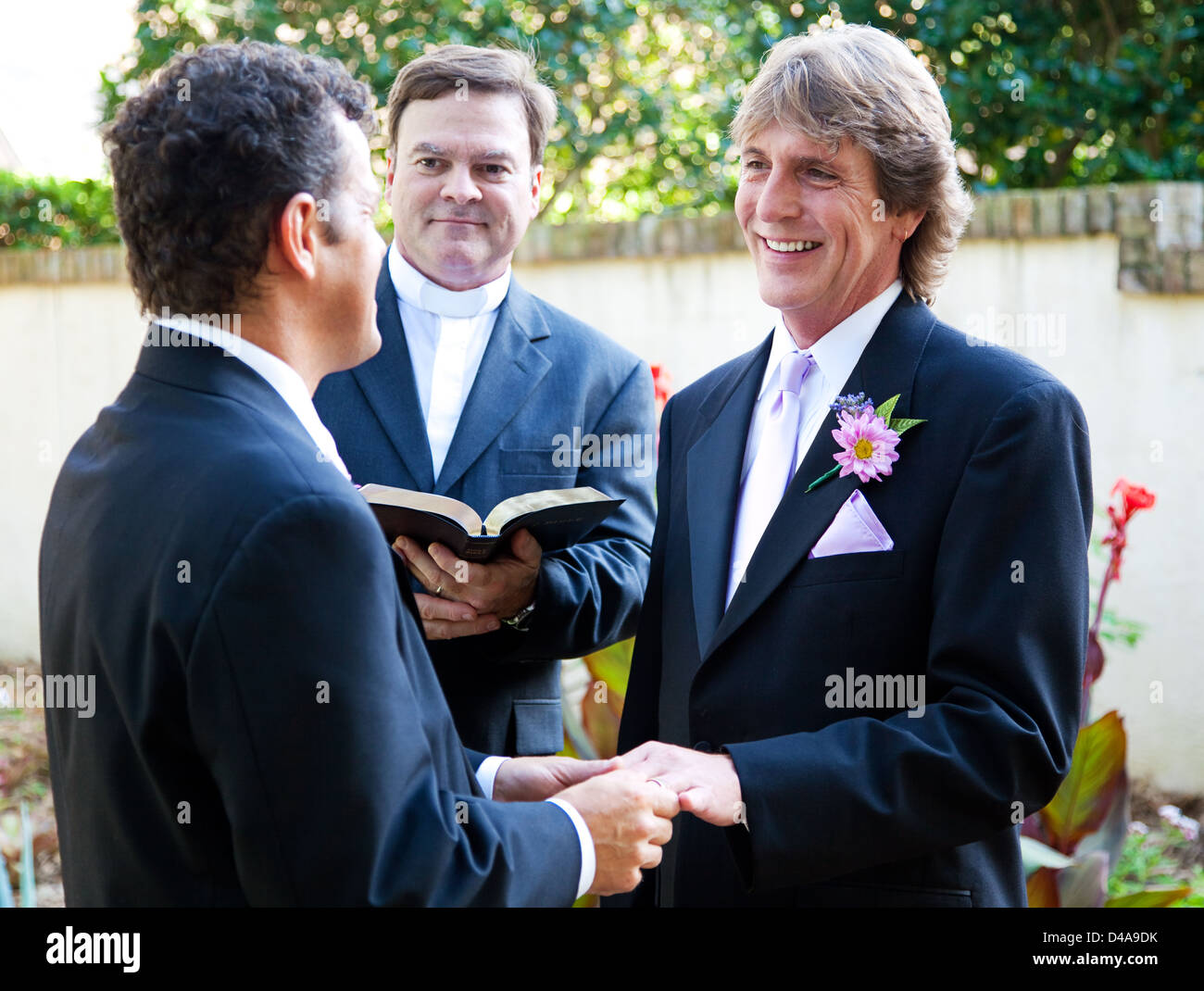 Gay couple exchanging rings and vows at their wedding.  Stock Photo
