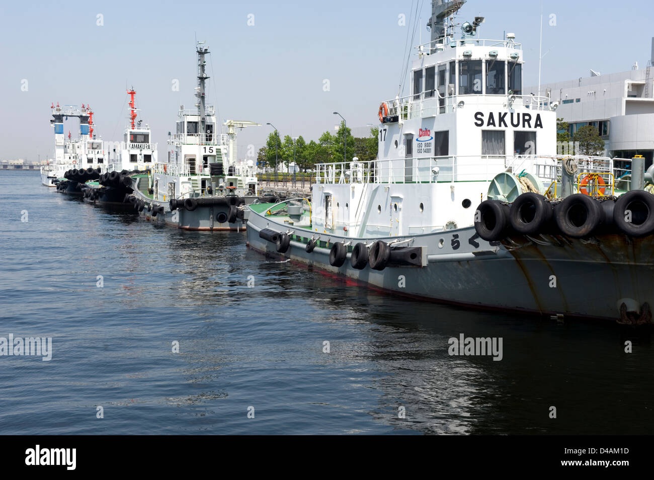 Tug boats moored at a commercial pier on Yokohama Bay waterfront, Yokohama, Kanagawa, Japan Stock Photo
