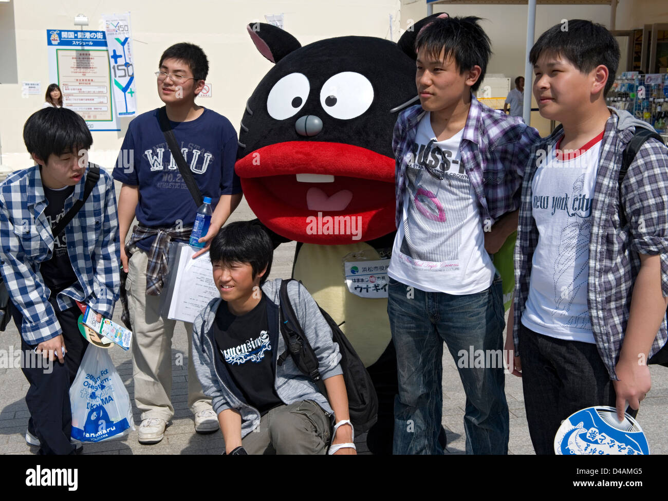 A group of students posing with a cute mascot character called 'Unagi Inu' (Eel Dog) from Hamamatsu City. Stock Photo