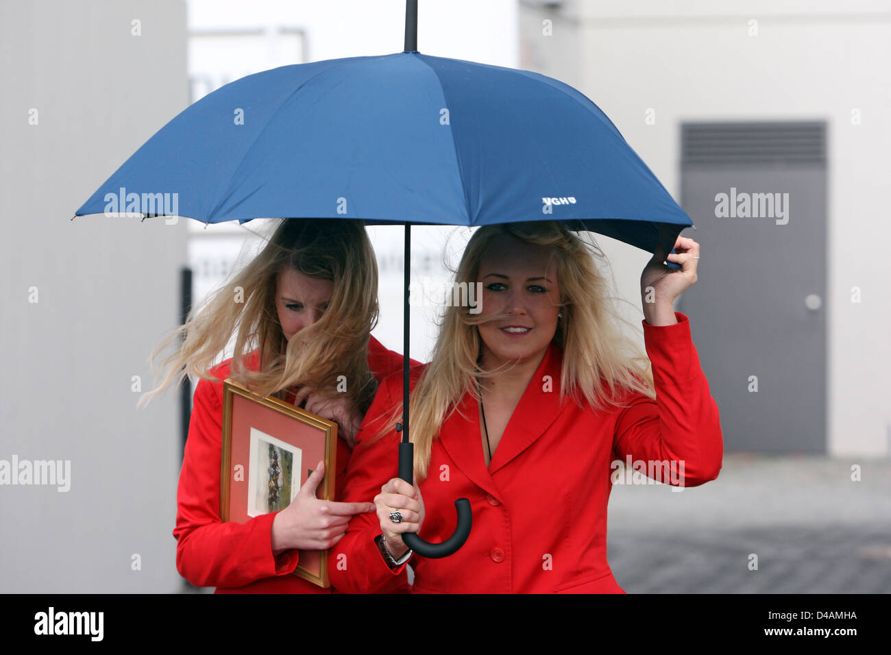 Hannover, Germany, women run together under an umbrella Stock Photo
