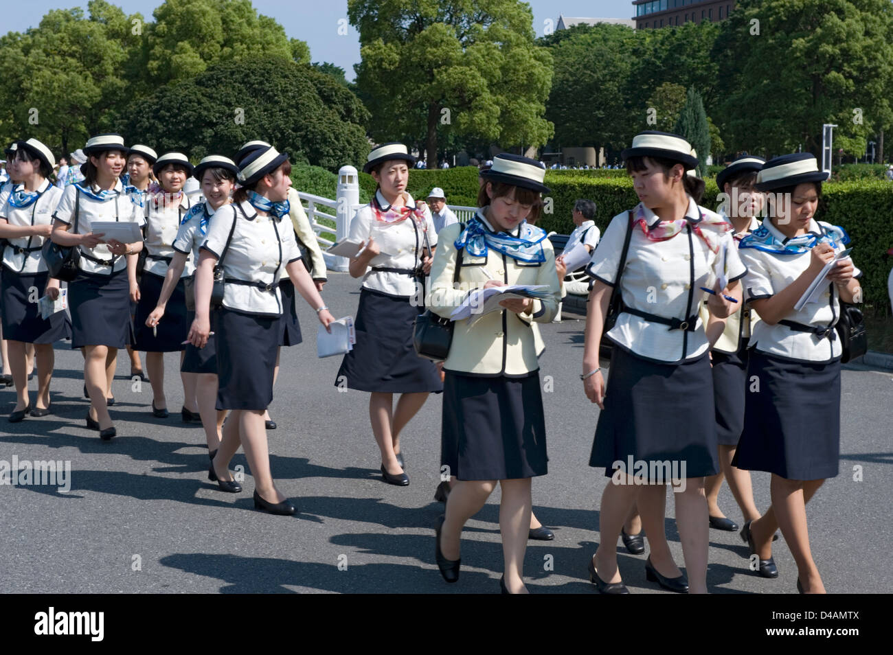 A group of women wearing tour guide uniforms taking notes while training in Yokohama, Japan Stock Photo