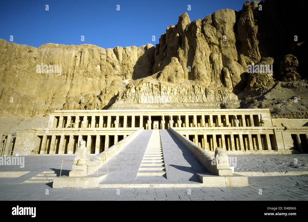 Sun rising on the Temple of Queen Hatshepsut (Foremost of Noble Ladies) at Deir el Bahri on Luxor's West Bank in Egypt. Stock Photo