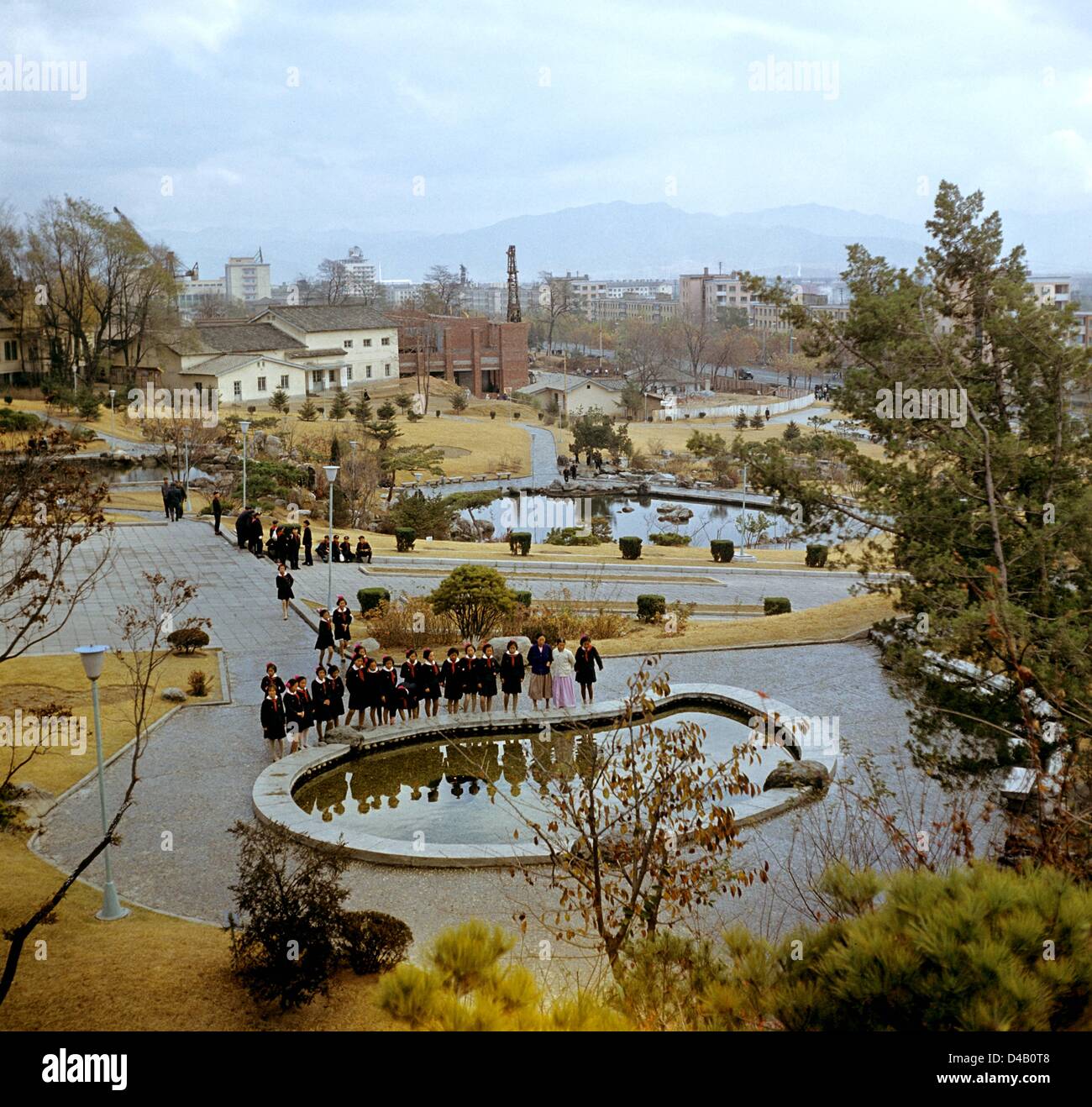 Girls in uniform with red scarves stand in a park at a water basin near Wilhelm-Pieck Street (in the background) in the harbour city of Hamhung  in the Korean Democratic People's Republic, photographed on the 6th of November in 1971. Hamhung was destroyed during the Korean War (1950-1953) and was reconstructed as an industrial centre with the decisive help ofthe GDR in the 50s and 60s.    Photo: ddrbildarchiv.de / Klaus Morgenstern - GESPERRT FÜR BILDFUNK Stock Photo