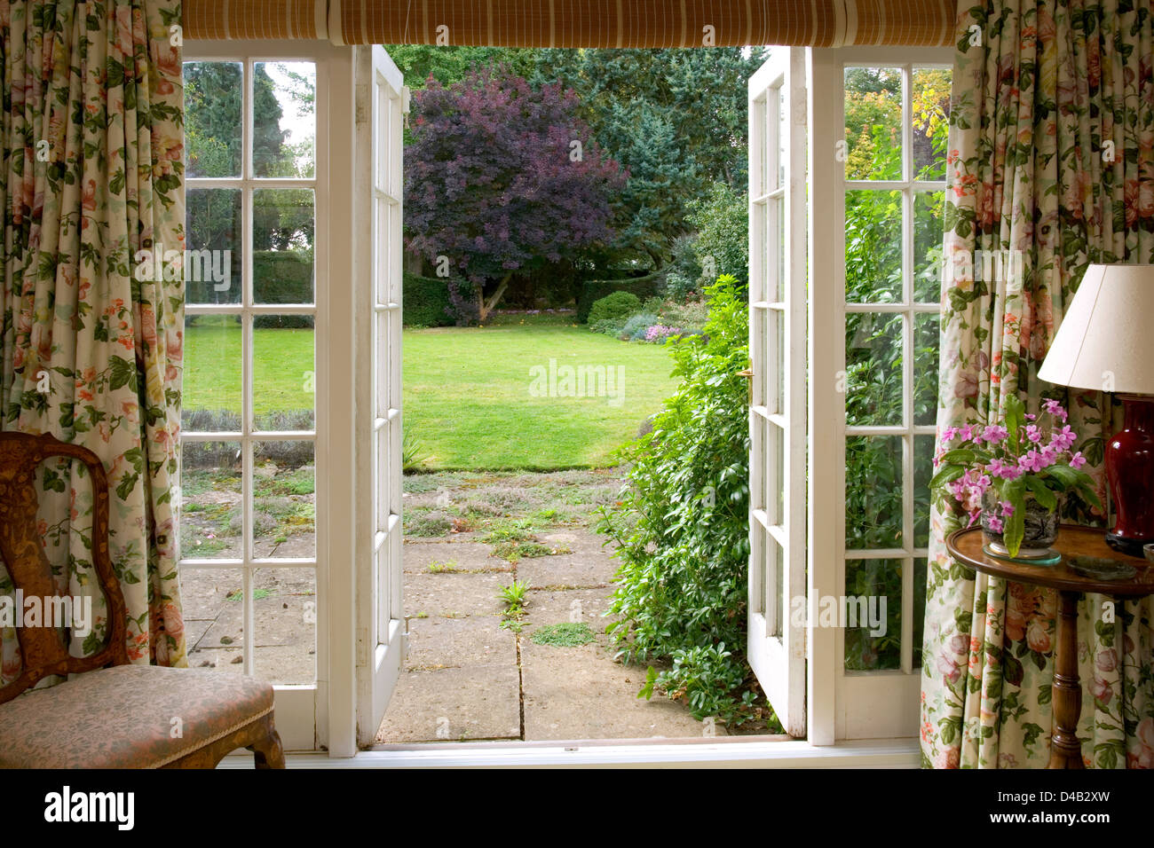 Traditional french windows opening onto a mature lawned garden Stock