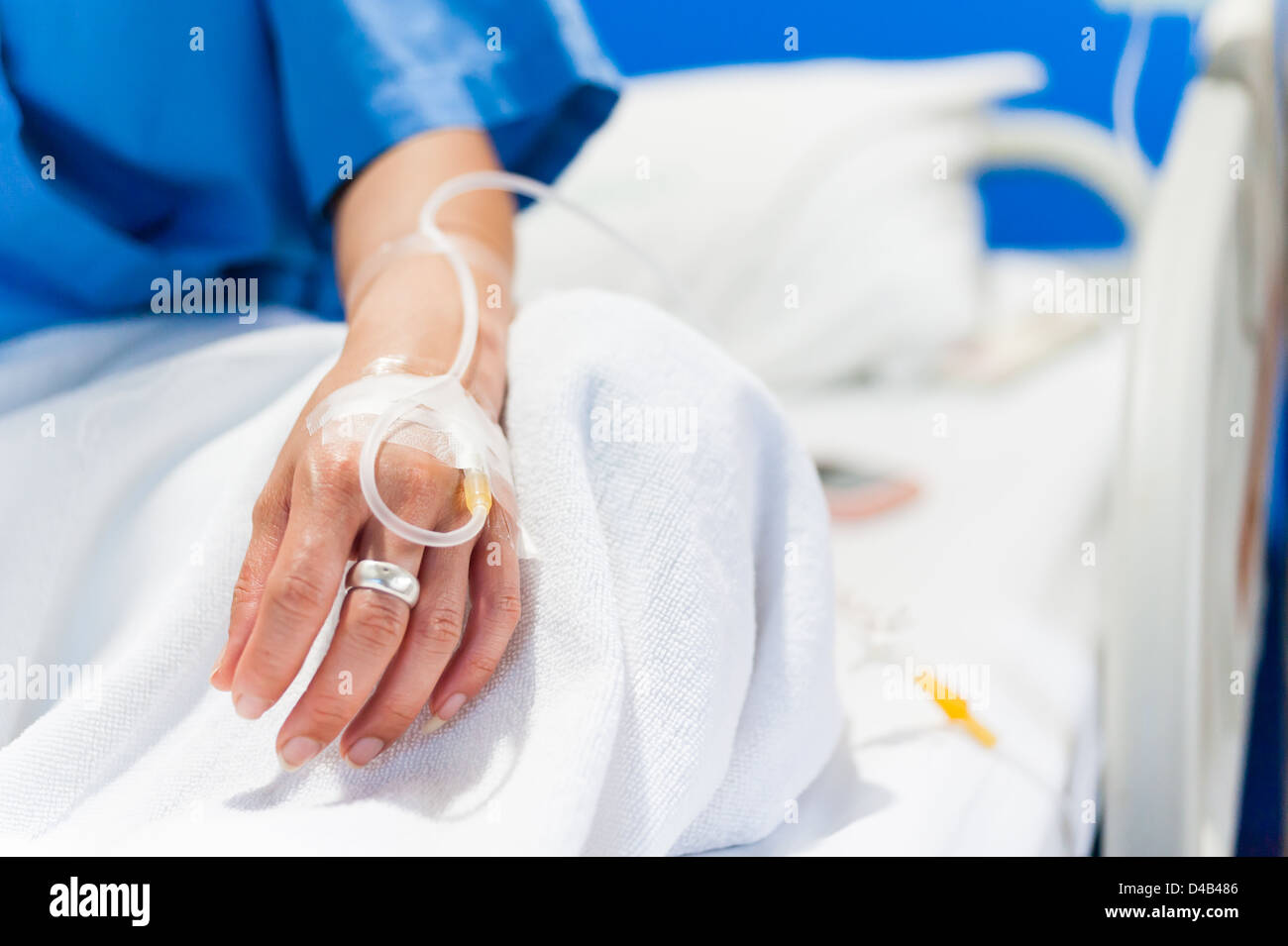 close up of iv drip in woman hand on bed in hospital Stock Photo